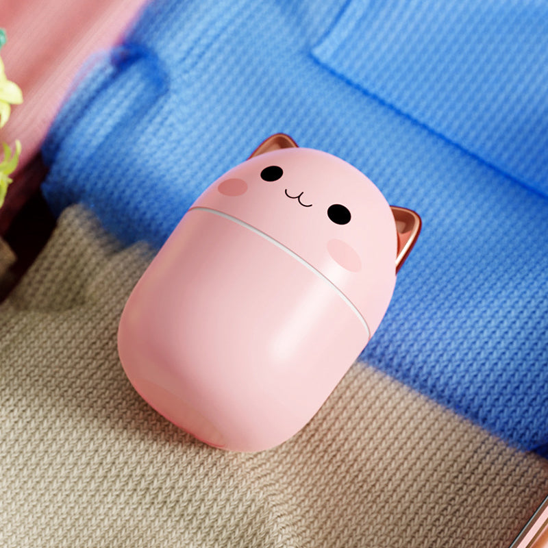 a pink cup with a cat on top of it