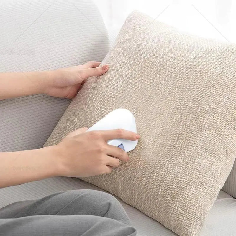a woman using a pillow to clean a couch