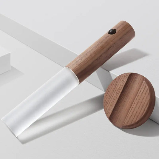 a knife with a wooden handle on a white surface