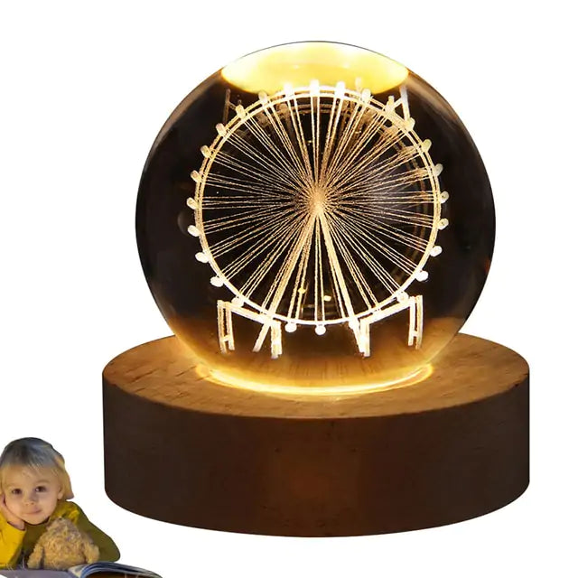 a small child sitting next to a light up ferris wheel