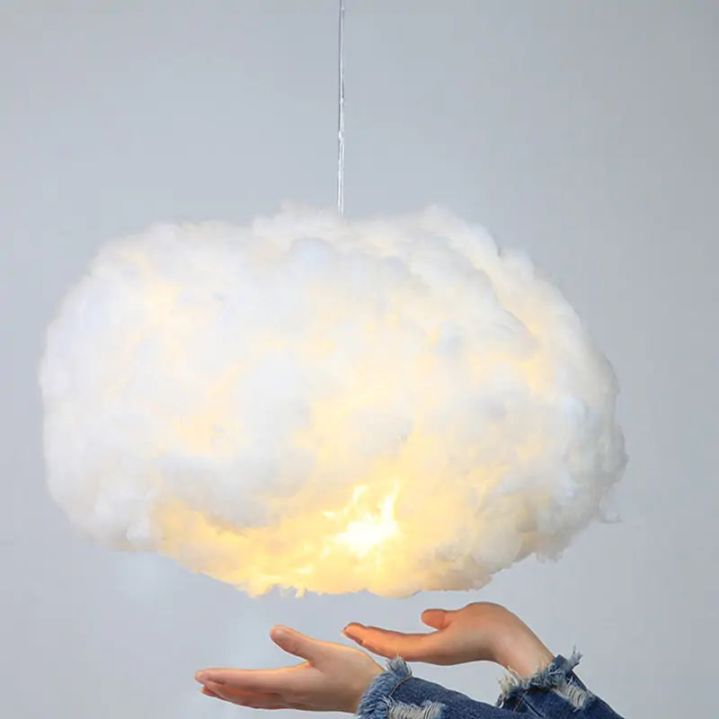 a person holding a cloud shaped light above their head