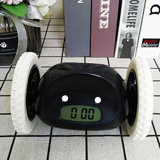 a black and white alarm clock sitting on top of a tiled floor
