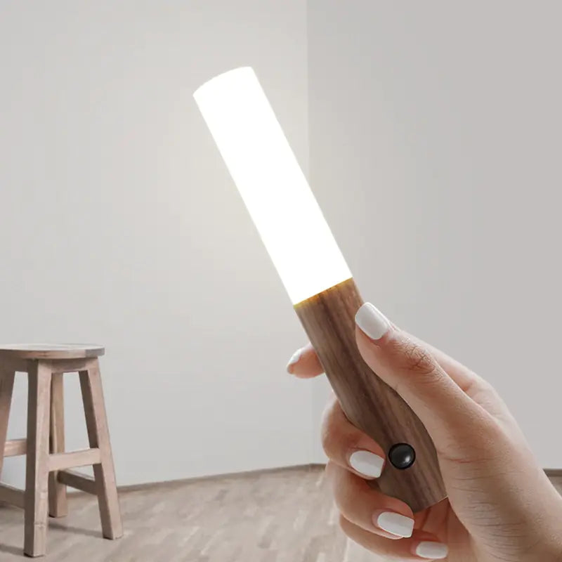 a person holding a wooden object with a light on it