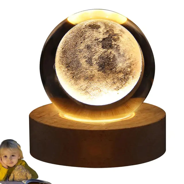 a small child sitting in front of a moon lamp