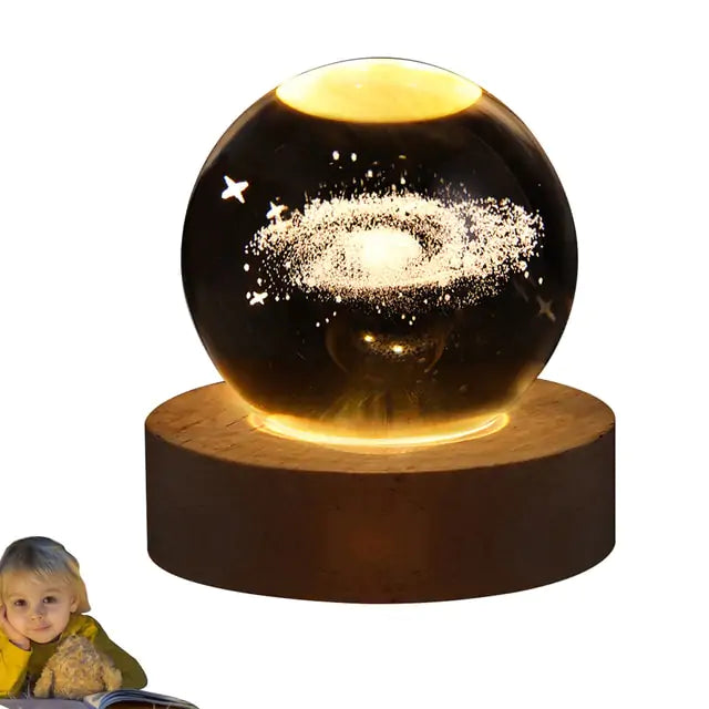 a little girl sitting in front of a glass ball